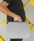 No Sweat Rolling Aluminum Toolbox With Handle Compact Storage Suitcase Heavy Duty Hard Shell Carry Case Built For Tools Portable Gear Crate held by a person next to a ladder.