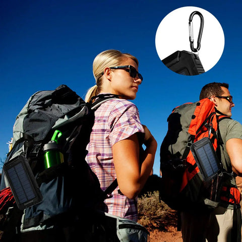 Hikers with backpacks equipped with Rugged 8000mAh Solar Charger Power Bank For Outdoor Adventures, featuring carabiner and compass.