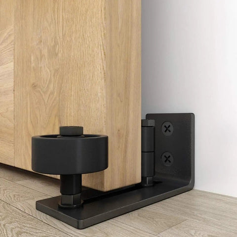 Rugged Barn Door Floor Guide With Fully Adjustable Sliding Track And Wall Mount Stabilizer For Slick Gliding Doors That Ride Steady And Roll Super Clean Through Everyday Grind, close-up showing black steel base and roller.