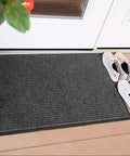 Heavy Duty Industrial Door Mat 3 By 10 Feet For Busy Entrances Large Commercial Grade Entrance Rug For Businesses Lobbies Garage And Mudrooms Charcoal Black Made In USA Brush Step 109S0310CH placed outside a door with shoes.