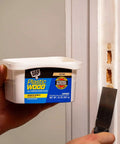 Plastic Wood All Purpose Latex Filler Natural 32 Oz in use repairing door trim with putty knife