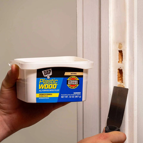 Plastic Wood All Purpose Latex Filler Natural 32 Oz in use repairing door trim with putty knife