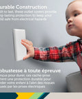 Toddler touching OutSmart Outlet Shield 2 Pack With Paintable Decoy Panels for unused outlets, with highlighted features.