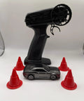 Mini RC Drift Car 1 To 64 Scale With LED Lights 4WD Pro Controls 2 Speed Modes Upgraded 2 4G Wireless Remote next to red cones