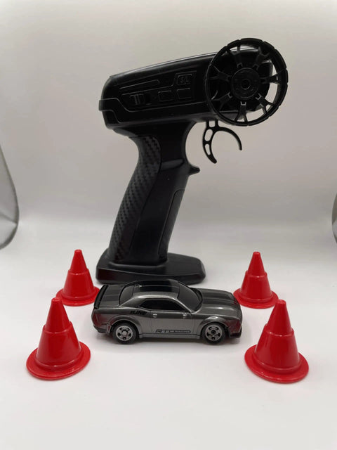Mini RC Drift Car 1 To 64 Scale With LED Lights 4WD Pro Controls 2 Speed Modes Upgraded 2 4G Wireless Remote next to red cones