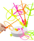 Colorful 50 Pack Flying Disc Toy Set With Swirly Sticks, Spinners, And Rings for Kids, shown with hand using Easy Pull And Fly Action.