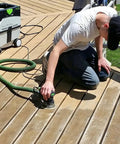 Person using 5-inch orbital sander with 40 Sheets Sanding Discs Kit With 60 80 100 120 150 180 240 320 Grits on deck