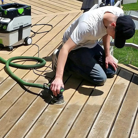 Person using 5-inch orbital sander with 40 Sheets Sanding Discs Kit With 60 80 100 120 150 180 240 320 Grits on deck