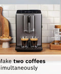 Fully Automatic Espresso Machine With Milk Frother System And Touch Control Panel Plus Cup Warmer For One Touch Latte And Cappuccino Maker In Sleek Dark Silver making two espressos in glass cups.