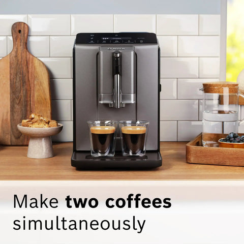 Fully Automatic Espresso Machine With Milk Frother System And Touch Control Panel Plus Cup Warmer For One Touch Latte And Cappuccino Maker In Sleek Dark Silver making two espressos in glass cups.
