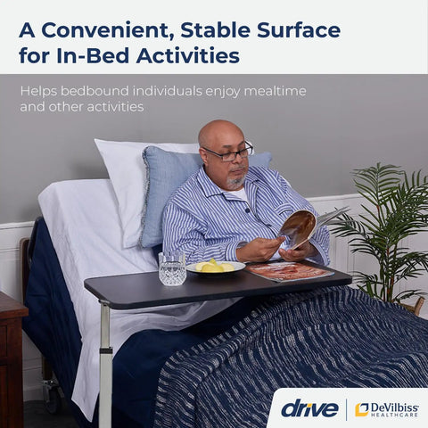Heavy Duty Adjustable Overbed Table With Dead Simple Height Changes Non Tilt Wood Grain Top And Smooth Rolling Swivel Casters For Zero Hassle Room Moves in use beside a bed with a man eating.