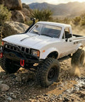 One Sixteenth Scale RC Crawler With Beefed Up Battery And LED Lights, Four By Four Off Road RTR Truck on rocky terrain