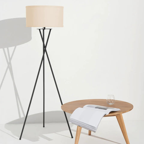 LED Floor Lamp Tall Tripod With Drum Shade In Black Finish And Gold Accents next to wooden table, modern living room decor