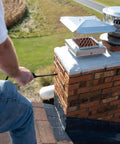 Heavy Duty Siloxane Chimney Brick Sealer Keeps The Wet Out For Good With A Clear Breathable Waterproof Coating That Shields Vertical Masonry Against Freeze Thaw Cracks For Rock Solid Dry Season Action One Gallon being applied to a chimney.