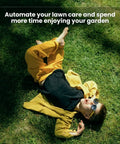 Child relaxing on grass enjoying garden while Big Yard Lawn Boss Robot Mower With 3600 Square Meters Coverage Per Charge And Four Hour Run Time 13.2Ah