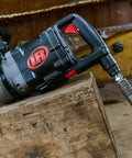 Badass 1 1/2 Inch Air Impact Wrench Blasts Through Frozen Lug Nuts With 7300 Nm Breakaway Torque Titanium Hammercase And Thru Hole Auxiliary Handle on wooden surface.