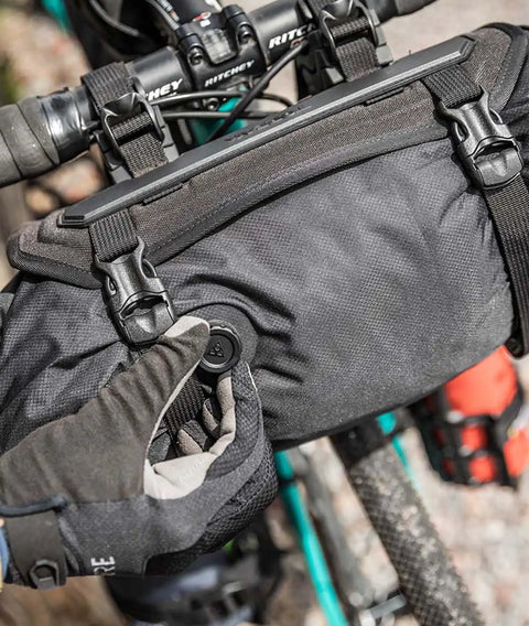 Cyclist adjusting air release on Frontloader 8 Liter Bar Bag For Bike Handlebar Mount, waterproof gear carrier shown on handlebars