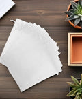 White Organza Drawstring Favor Bags Pack Of 100 Reusable Mesh Pouches on table with plants