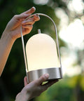 Hands holding Battery Powered Outdoor Lantern Table Lamp Waterproof 4000mAh Cordless Rechargeable 4 Level Touch Dimmable Lit Night Light