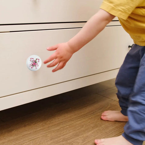 Festive Peppermint Ceramic Knob Covers For Cabinets And Drawers Super Easy Install Holiday Home Refresh Essentials Decorative Drawer Pulls With Screws For Winter Party Vibes Quick Upgrade. Child's hand reaching for a white ceramic knob on a drawer.
