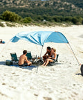 Three Pack Beach Shade Accessories Kit with nylon ropes and ratchet pulleys in use on a sandy beach with people relaxing underneath.
