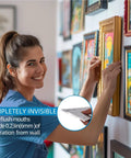 Woman installing a framed picture using the Rock Solid Forty One Inch French Cleat Hanger Kit With Heavy Duty Aluminum Z Clips.