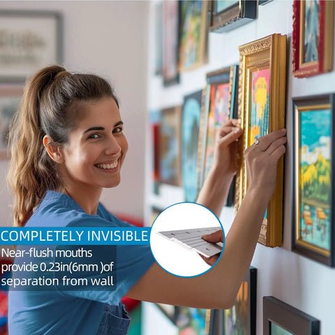 Woman installing a framed picture using the Rock Solid Forty One Inch French Cleat Hanger Kit With Heavy Duty Aluminum Z Clips.