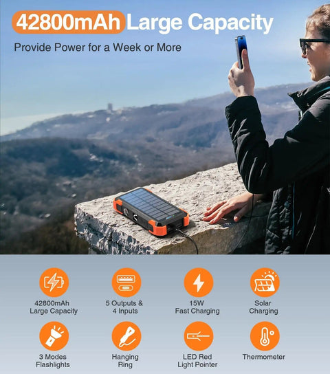 Solar Charger Power Bank With Built In Cables And 42800mAh Battery on mountain ledge with person holding phone
