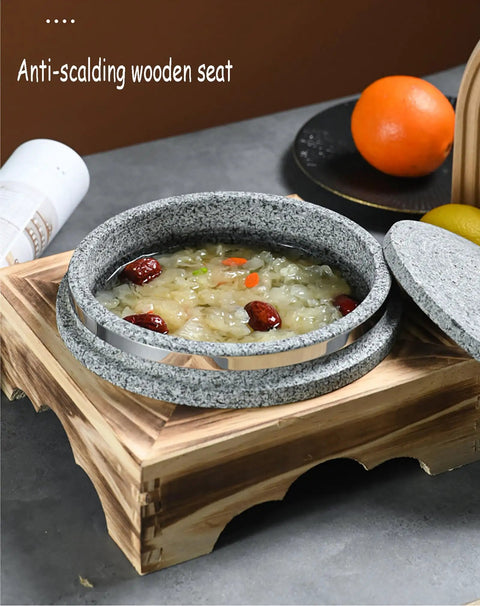 Dolsot style granite stone bowl with lid, 14 cm, on wooden holder, filled with soup, showcasing heat-retaining features.