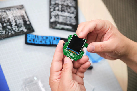 Clockstar 2.0 DIY Smartwatch Kit Build and Code Your Own Wearable Tech Learn Real Electronics and Coding in a Hands On STEM Gift for 11 Plus Kids and Teens green smartwatch circuit board in hands