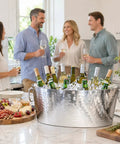 Armored XL Insulated Beverage Tub For Parties, double wall stainless steel ice bucket with wine bottles on a kitchen counter.