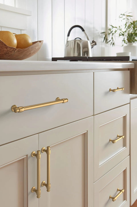 Champagne Bronze Traditional Cabinet Pull installed on kitchen cabinets, showing five and one sixteenth inch center to center mounting.