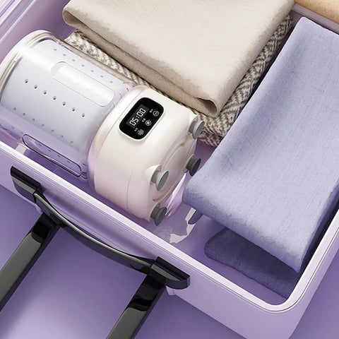 Portable Mini Washing Machine Cordless Compact Laundry Spin Dryer in a drawer, with fabrics stacked neatly around.