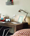 Smart In-Wall USB Charger With 15A Tamper-Resistant Outlet installed near a desk with a laptop and lamp.