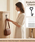 12 Pack Heavy Duty Cast Iron Coat Hooks Wall Mounted Black Workhorse Wall Storage For Coats Bags Built Tough For The Daily Grind With A Sleek Flat Black Finish That Lasts In Any Room on a wooden cabinet holding a handbag.