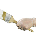 Hand holding a paintbrush covered in white paint while wearing Heavy Duty Clear Vinyl Industrial Gloves Case Of 1000 Units 3 Mil Thick Build.