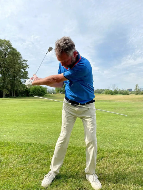 Golfer using Golf Belt Laser And Rod Mount For Swing Training And Putting Alignment Securely Attaches To Back Chest Or Hip outdoors.