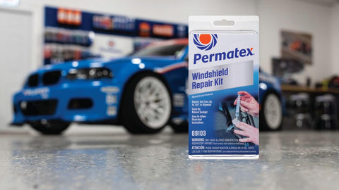 Windshield Repair Kit For Chips And Cracks With Permanent Airtight Seal package in front of blue car in garage