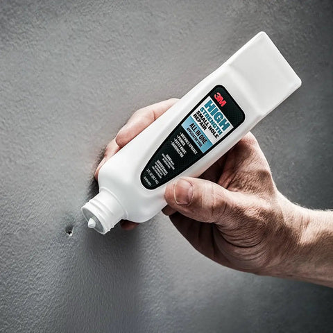 Person using All In One Wall Repair Kit With Putty Knife Spackle And Sanding Pad For Quick Fix Of Nail Holes And Small Dings Up To 3 Inches And Primer Enhanced Spackling.