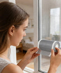 Woman applying DIY Window Screen Repair Tape Waterproof Mesh Patch for home bedroom living room bathroom kitchen dorm office garage holes.