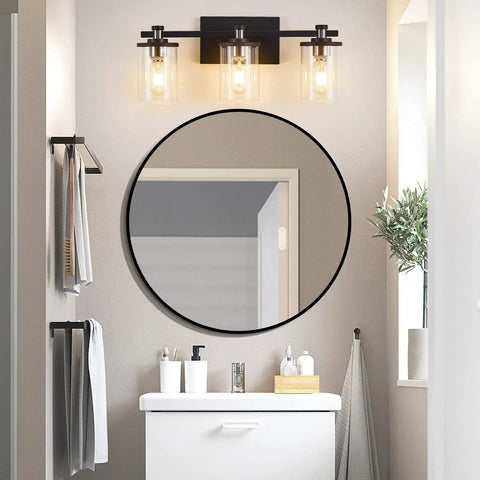 Three Light Matte Black And Brushed Nickel Bathroom Vanity Light Fixture over mirror with clear glass shades in modern bathroom