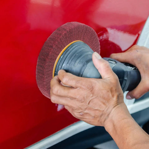 Heavy Duty VOSAREA Bench Grinder Buffing Wheel With Nonwoven Abrasive Cloth polishing a red surface with grit 320.
