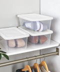 Clear Plastic Storage Bins With Lids 6 Quart Stackable Organizer Boxes on a closet shelf, containing shoes for easy organization.