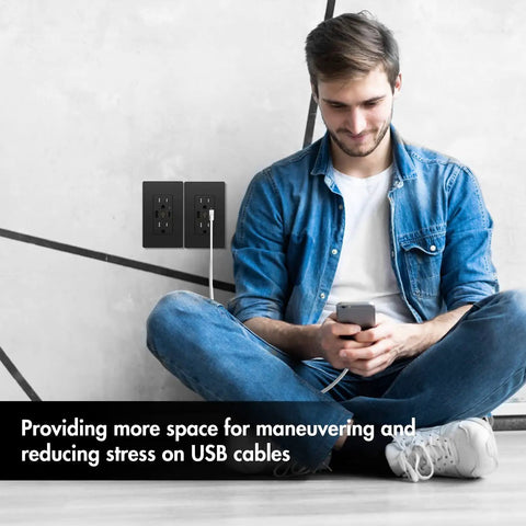 Man sitting near dual USB C and A wall outlet with 4.8A fast charging, 15A 125V, tamper-resistant receptacle and wall plate, 2 pack, black.