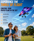 Couple flying Power Up RC Paper Airplane Kit with gyro stabilizer and constellation themed design outdoors.