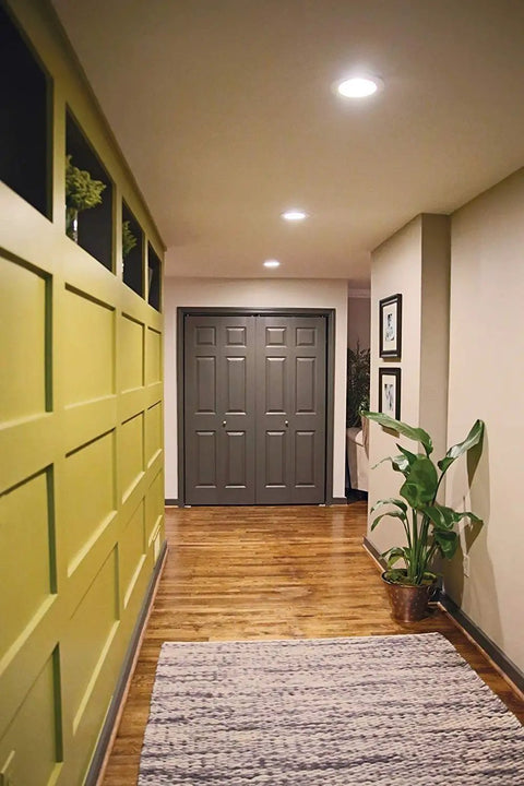 Slick 12W Recessed LED Downlight Boasting Deep Anti Glare Lens illuminating a hallway with stylish decor and wooden flooring.