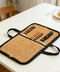 Durable Portable Chefs Knife Roll With 4 Slots Grab And Go Water Repellent Canvas Knife Storage Bag open on table with knives