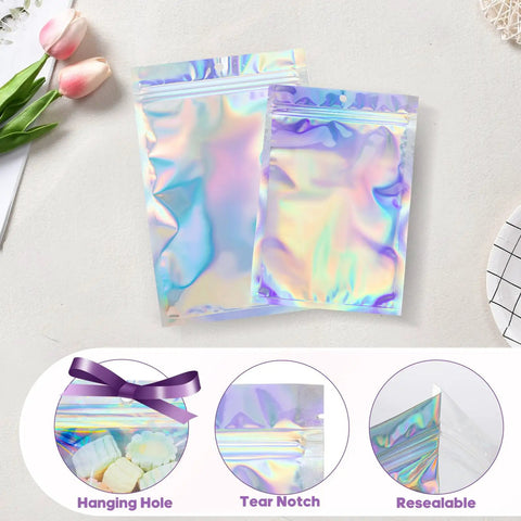 Holographic Packaging Bags 3.1x4.7 Inch Resealable Foil Mylar Pouches with hanging hole, tear notch, resealable feature, displayed on table.
