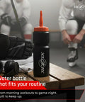 Hockey Hydration Bottle With Long Spout For Fast Sips 25 Oz in locker room on bench with sports gear