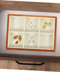 Premium Solid Wood Desktop Jewelry Organizer Tray With Divided Grid Compartments For Rings Necklaces Earrings And Watches Durable Storage Holder displaying rings and earrings organized in a compartmentalized tray.